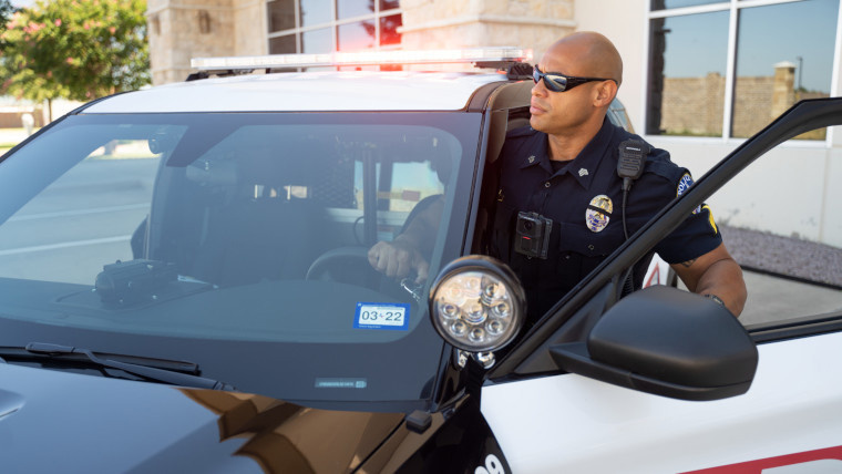 A policeman getting in a police car